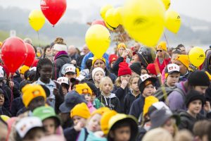 lots of kids walking together with reconciliation ballons