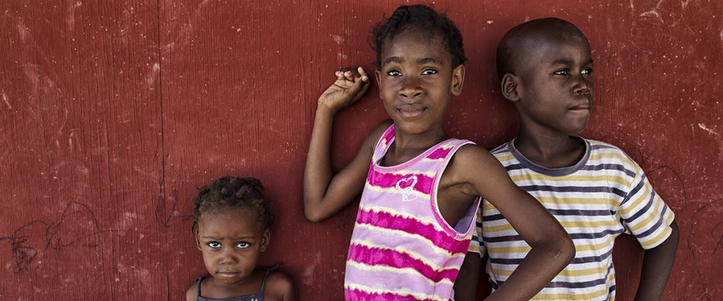 children standing against a wall
